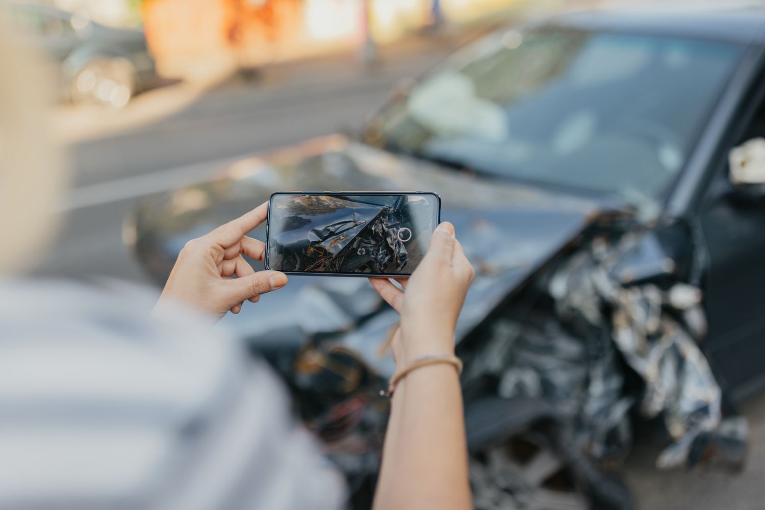 Person using a phone to take a photo of a car accident