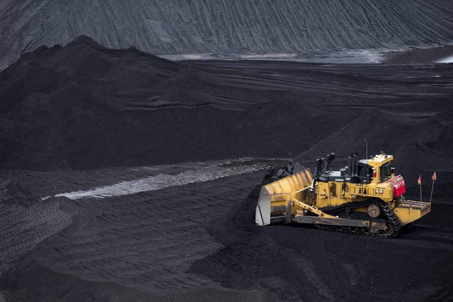 A bulldozer smoothes a coal pile in the storage yard at Consol Energy Inc.'s CNX Marine Terminals Inc. coal transshipment marine terminal in Baltimore, Maryland