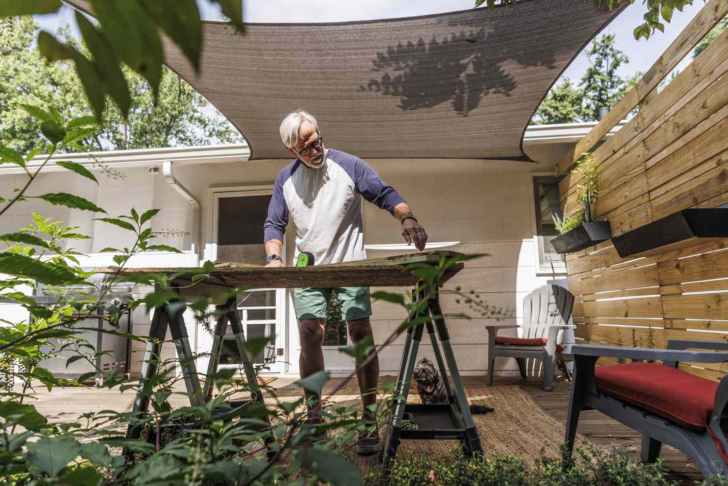 A man cuts wood outside his home