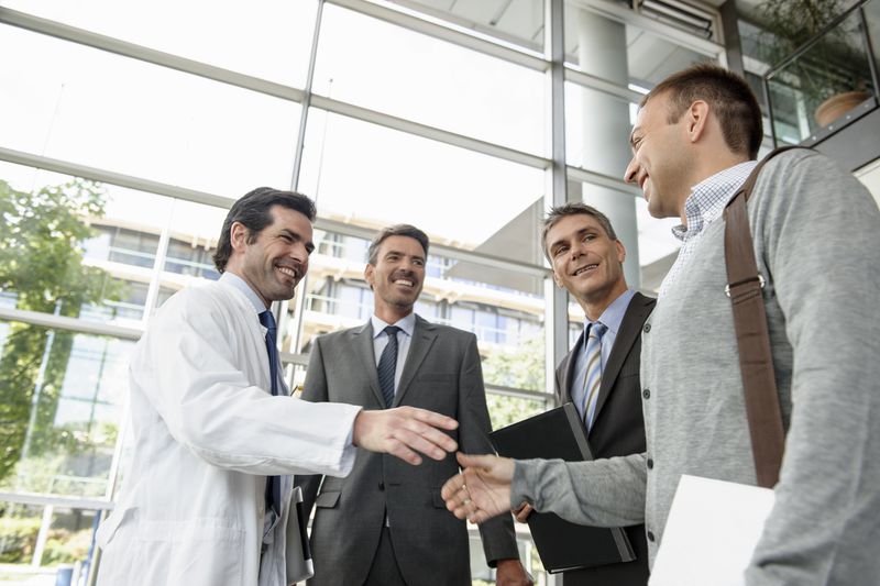 Doctor and businessman shaking hands.