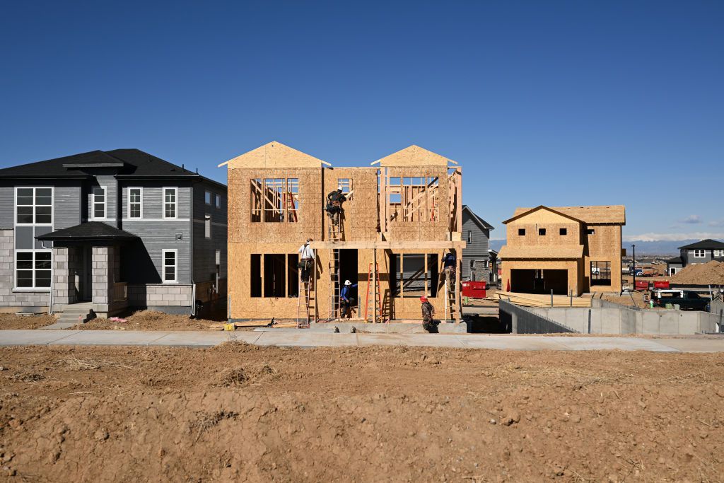 Construction crews work to build new homes in a subdivision by Tri Pointe Homes Colorado in Aurora Highlands, Colorado on April 8, 2024