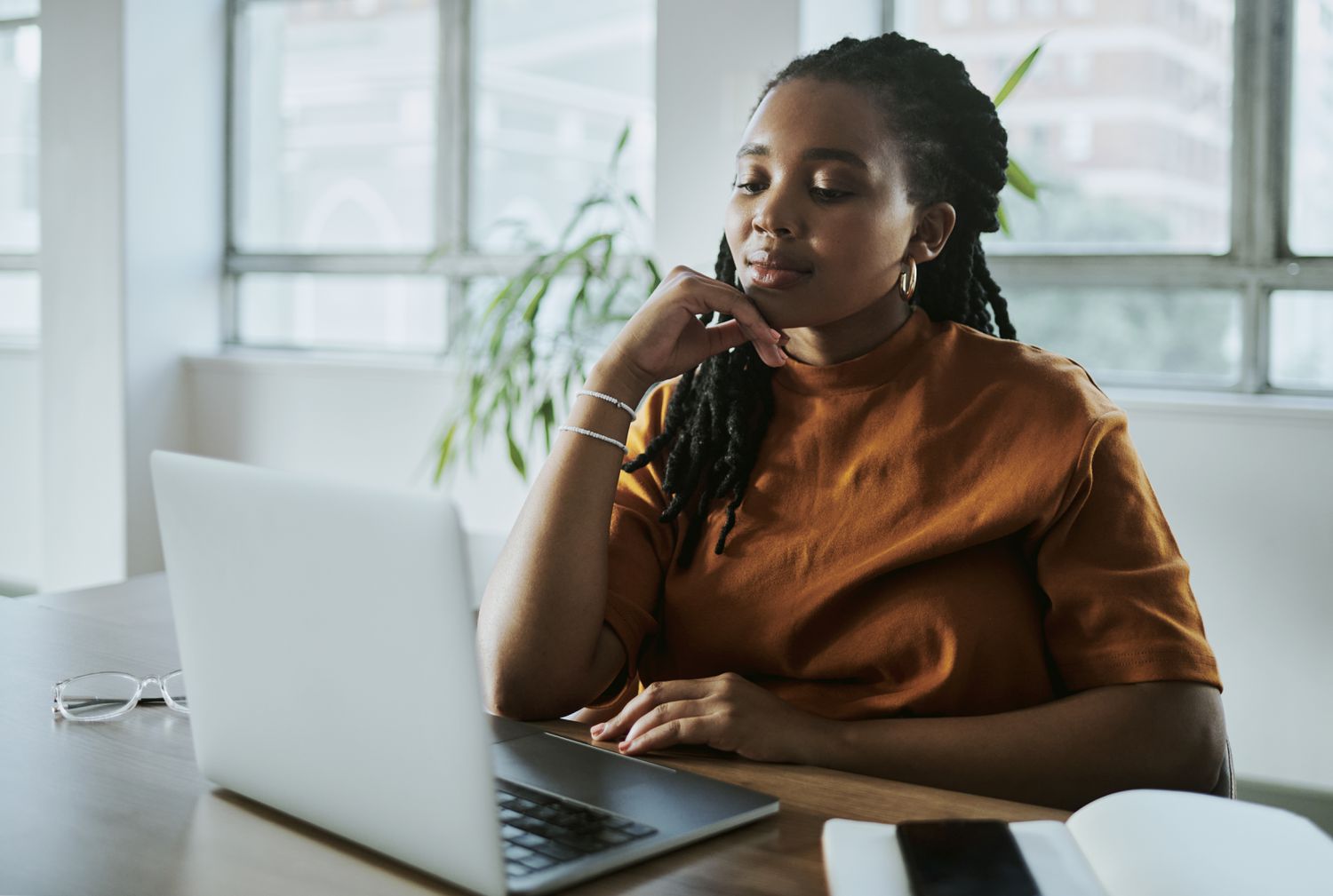 A young Black business woman working on her laptop computer.