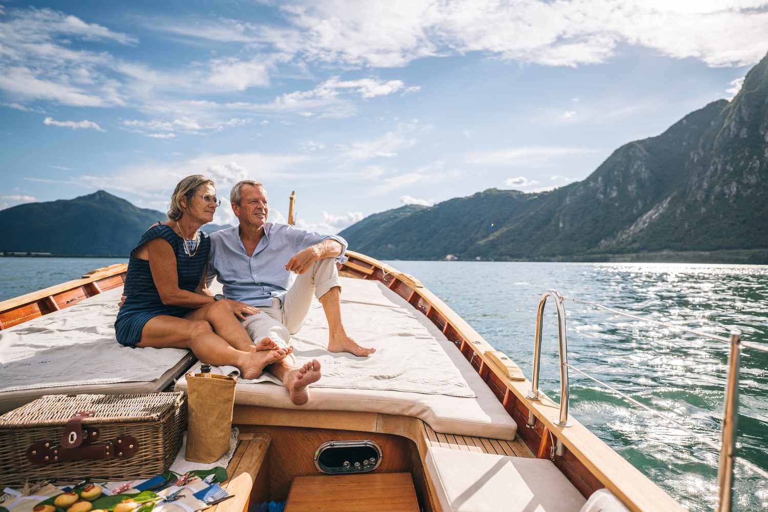Elderly couple sitting on a sailboat in a large lake