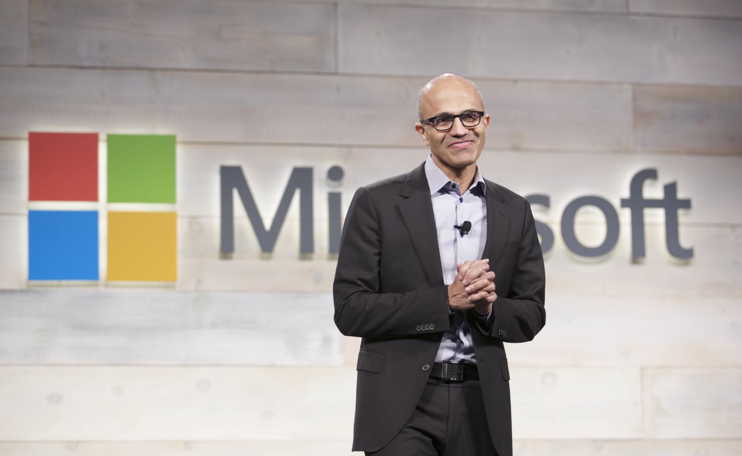 Microsoft CEO Satya Nadella in front of the company's logo. 