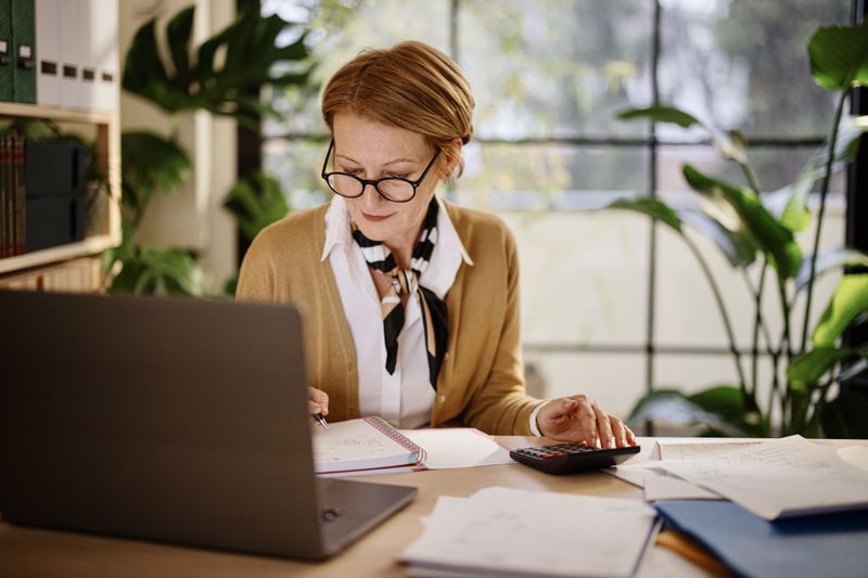 A woman with a computer and a calculator