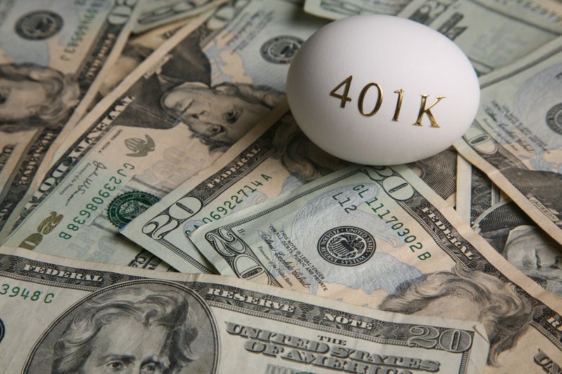 A 401(k) egg sitting on a pile of $20 bills