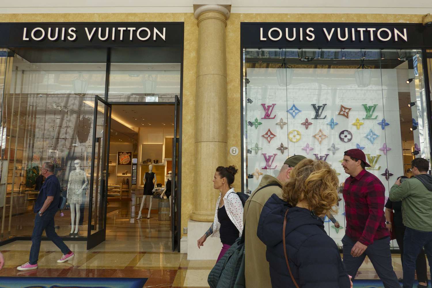 People pass by a Louis Vuitton store.