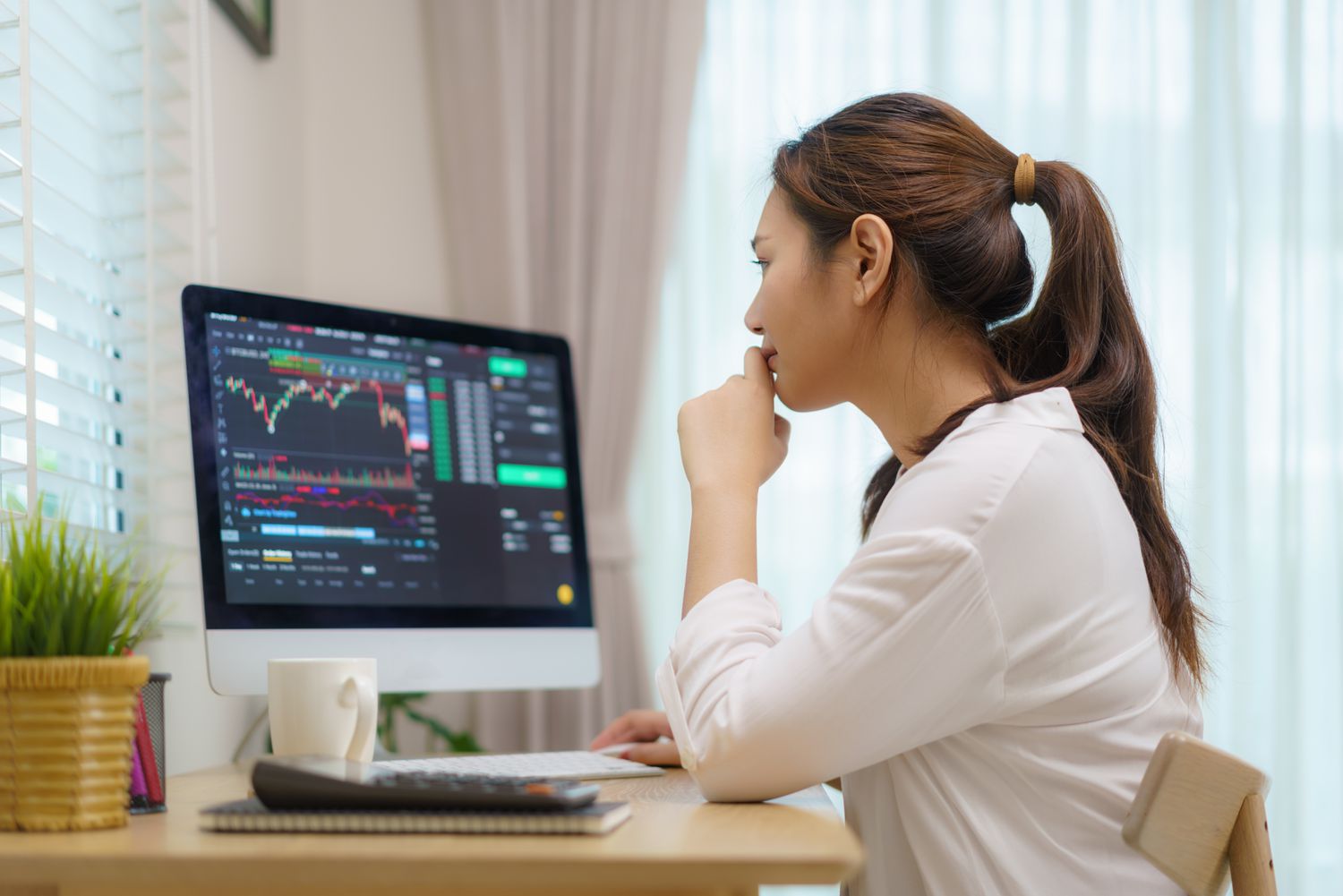 Person sitting at a computer looking at stock data