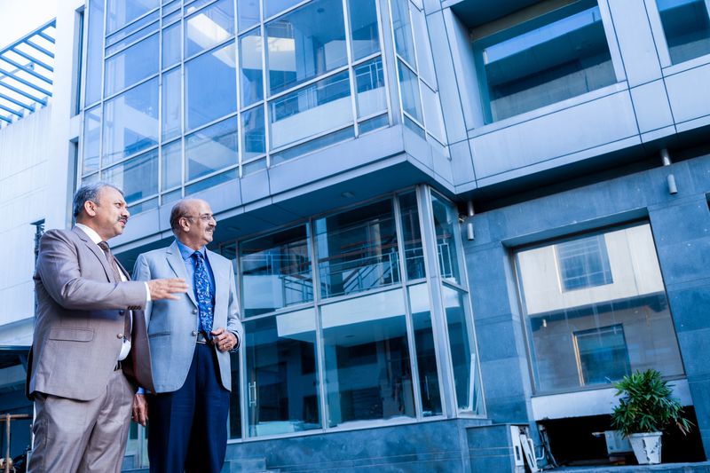 Two men talking outside a building
