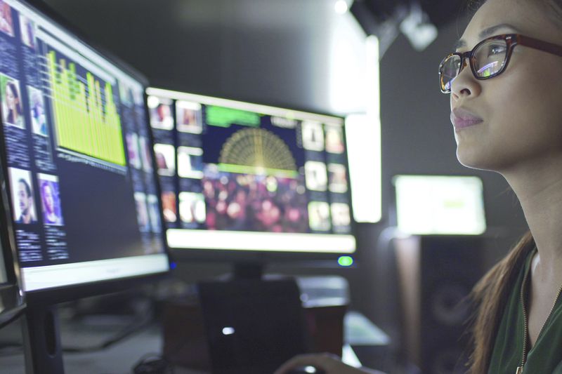 Investor reviews stock market data on several monitors