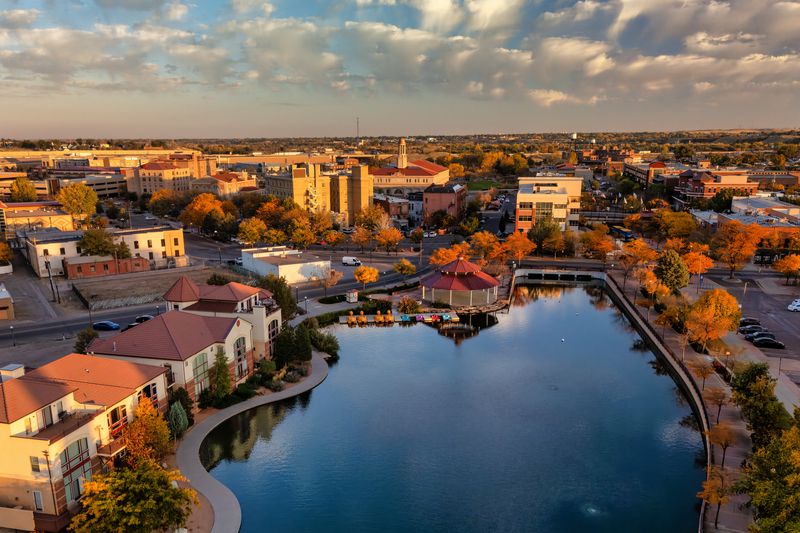 Aerial of Downtown Pueblo, Colorado during autumn with a lake in the foreground.