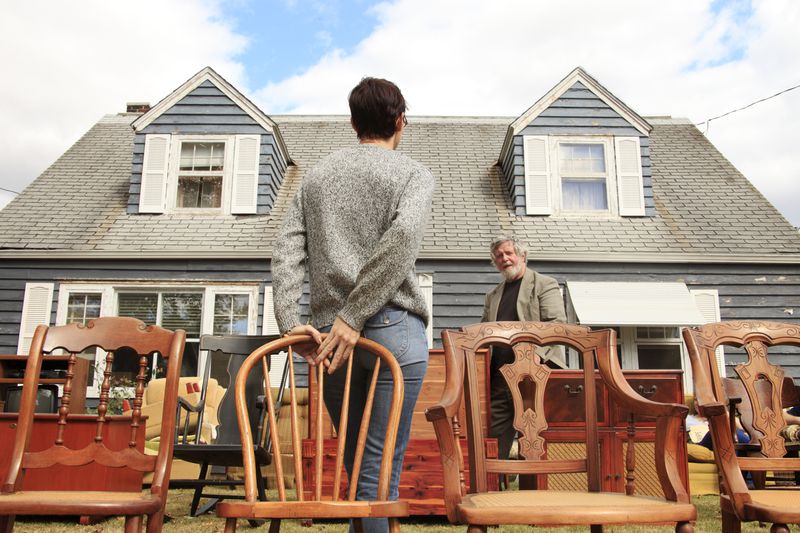 People standing in front of a house and talking before a bidding war in the auction for the house starts.
