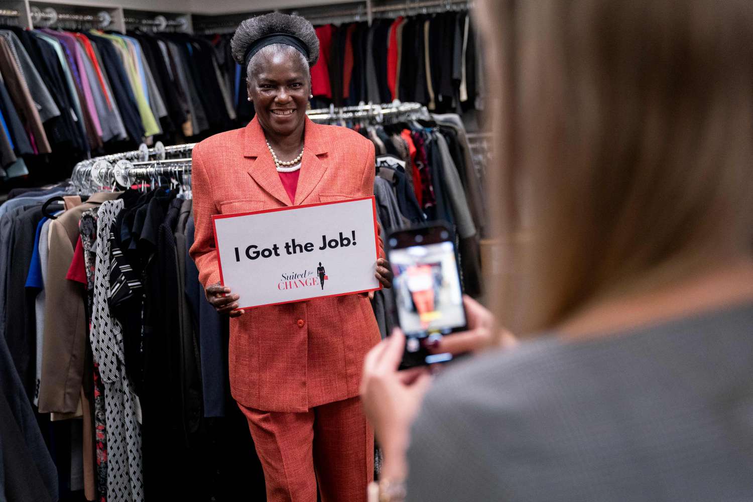 Donna Howard holds up a sign reading I Got the Job at Suited for Change in Washington, DC, on September 13, 2022.