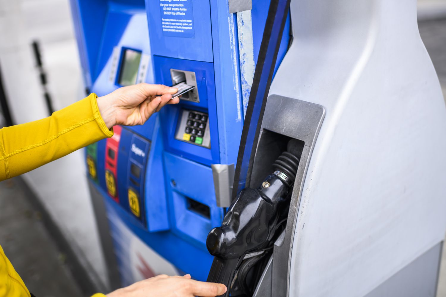 A person paying for gas at a fuel station with a card.