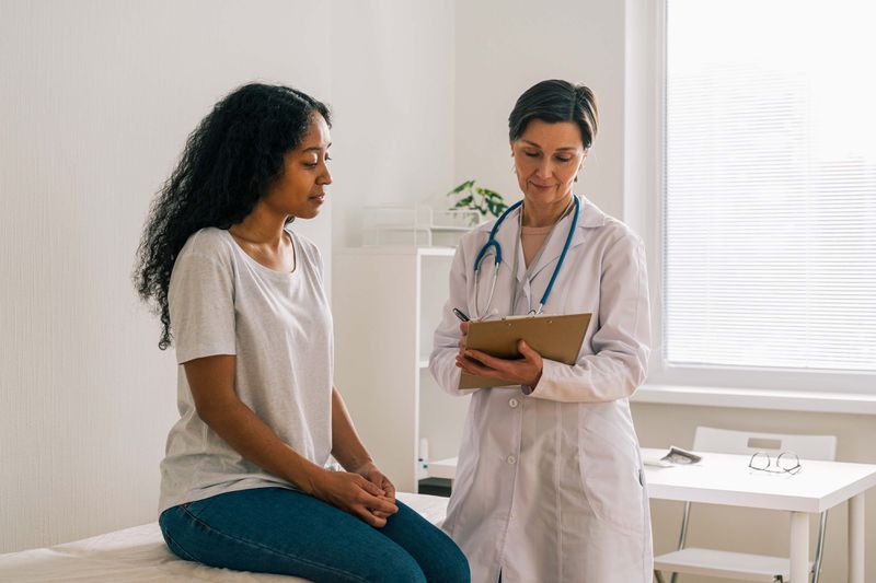 African-American female patient visiting doctor office telling about symptoms
