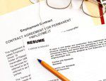 Resume, employment contract, eyeglasses, and a pen.