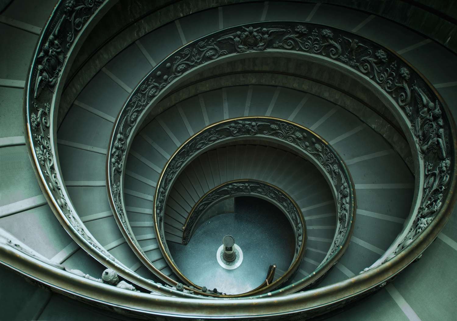 A spiral staircase as seen from above going down several flights. 