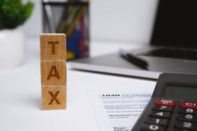 Three wood blocks spelling tax on tax forms