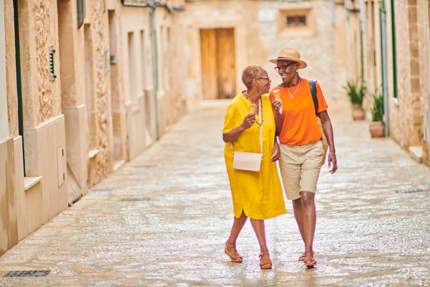 Two female tourists walking down a street in Spain