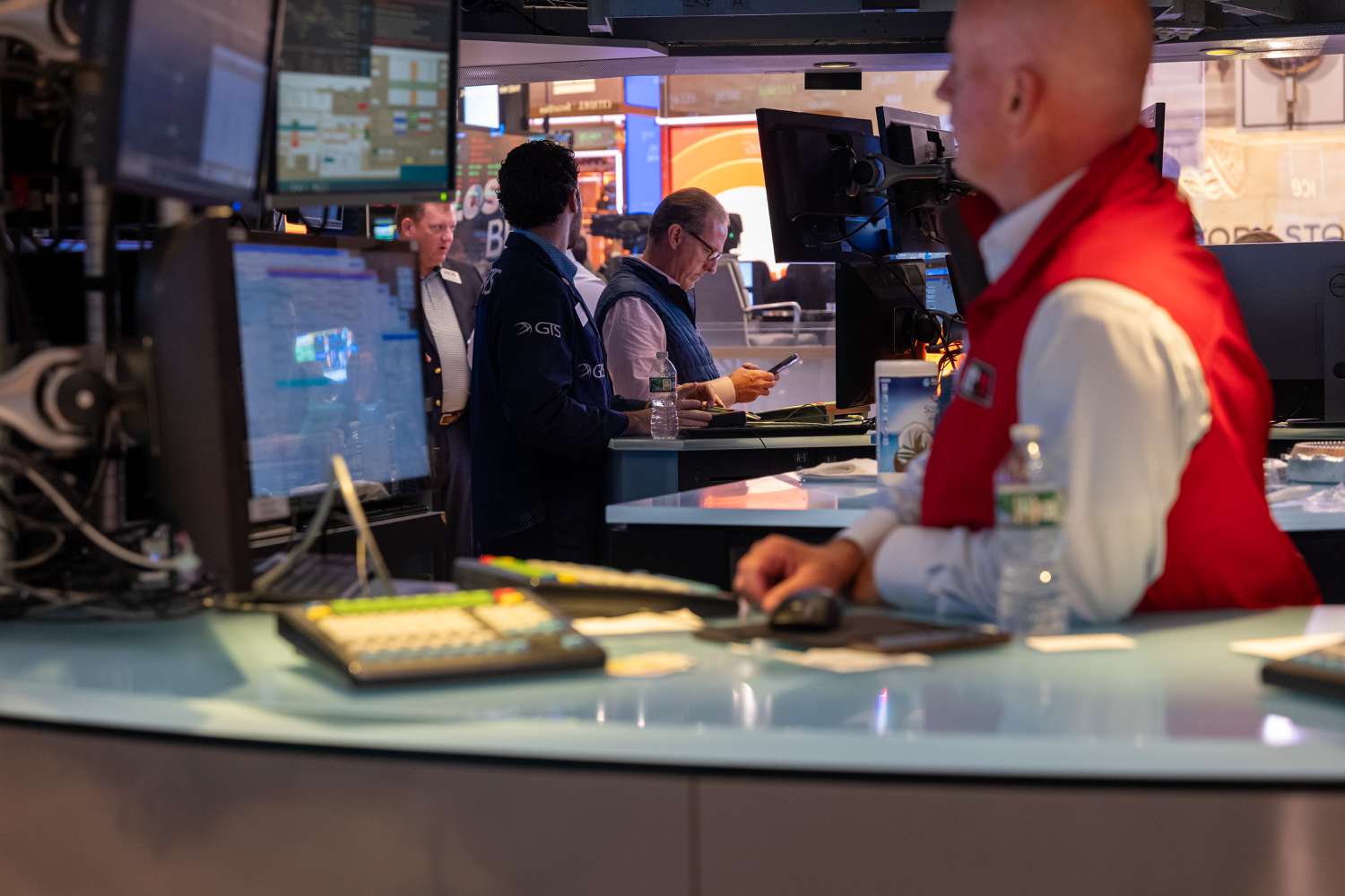 People walk on the floor of the New York Stock Exchange (NYSE)