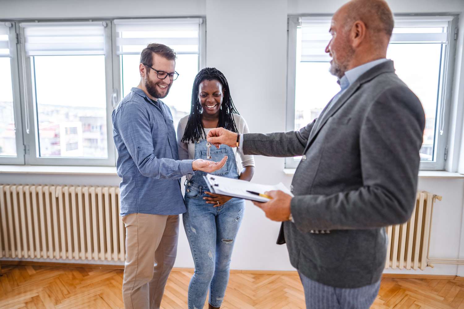A couple is receiving their house key after finalizing the purchase of the property with a wet loan.
