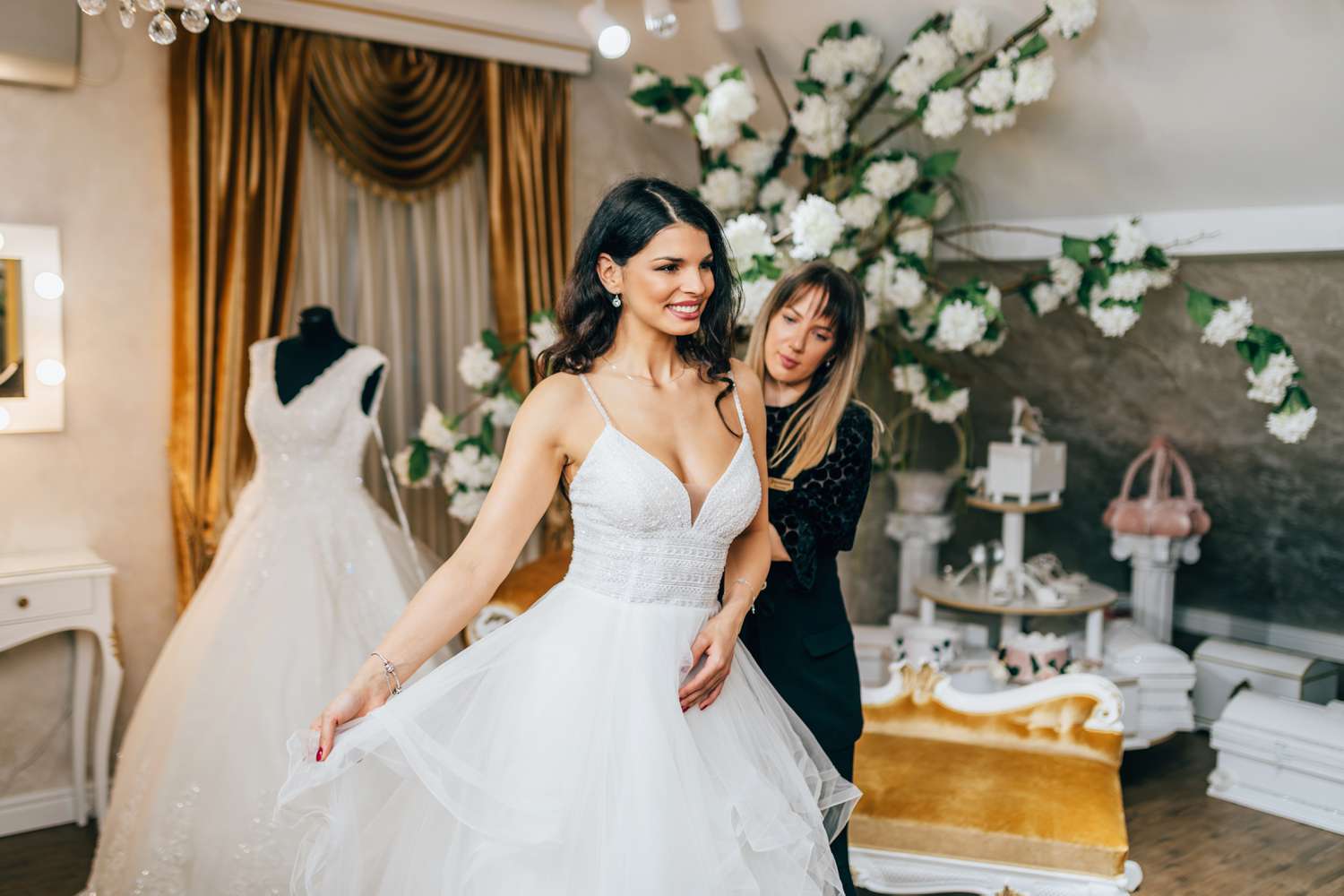 Beautiful young woman choosing a wedding dress in a modern wedding salon.