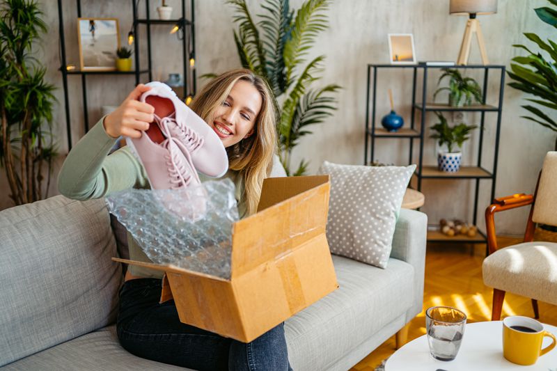 A woman taking shoes out of an online package