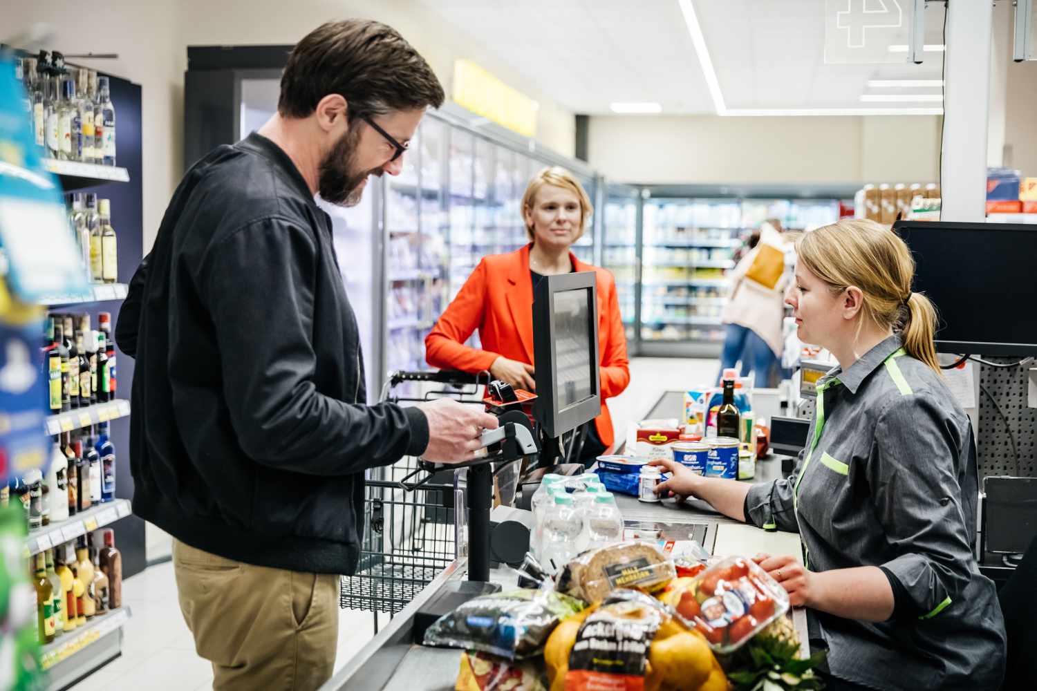 A couple paying for their groceries at the checkout in their local supermarket.