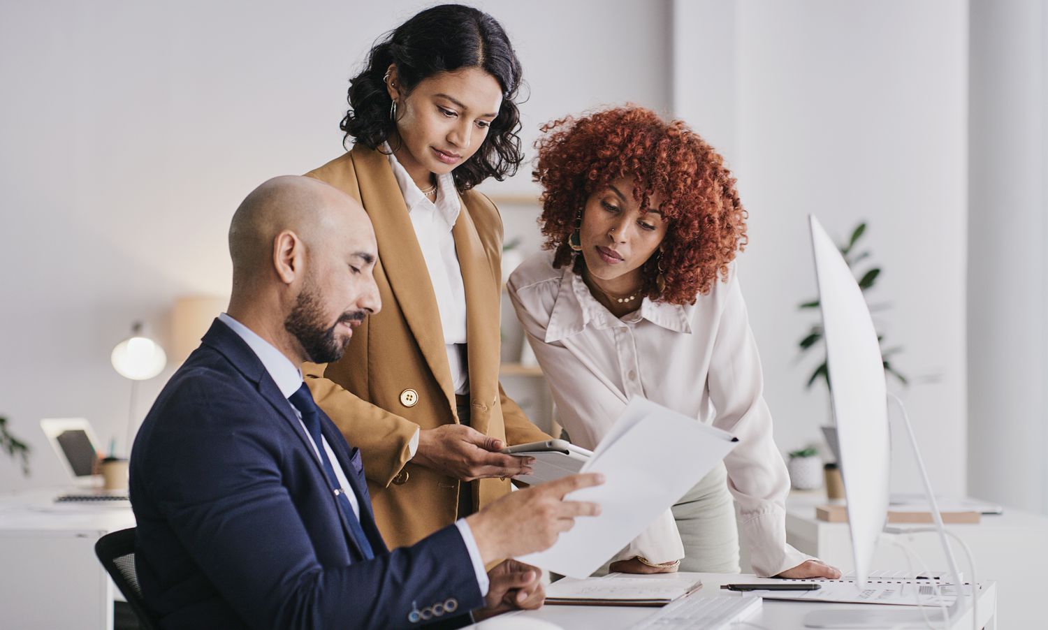Company executives and financial officer meet in an office to discuss an increase in the number of company shares available to investors.