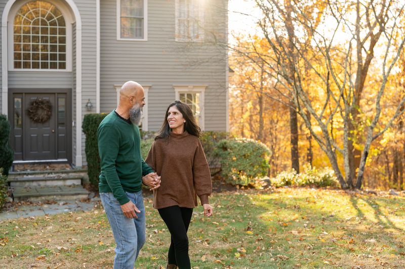 Couple walking in front of their house.