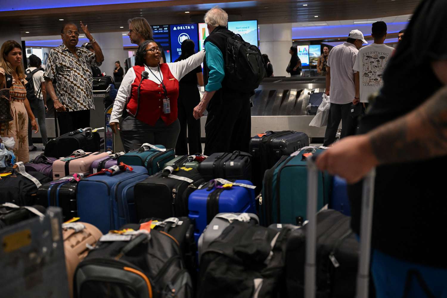 A Delta employee assists customers looking for bags in the Delta Air Lines baggage claim area Los Angeles International Airport (LAX) on July 24, 2024