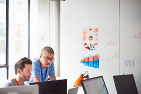 Two businessmen working together at the computer