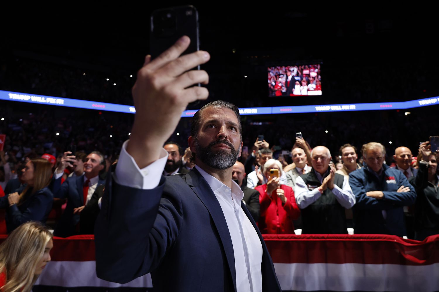 Donald Trump Jr. records video as his father, Republican presidential nominee, former President Donald Trump, arrives for a campaign rally at Van Andel Arena on November 05, 2024 in Grand Rapids, Michigan.