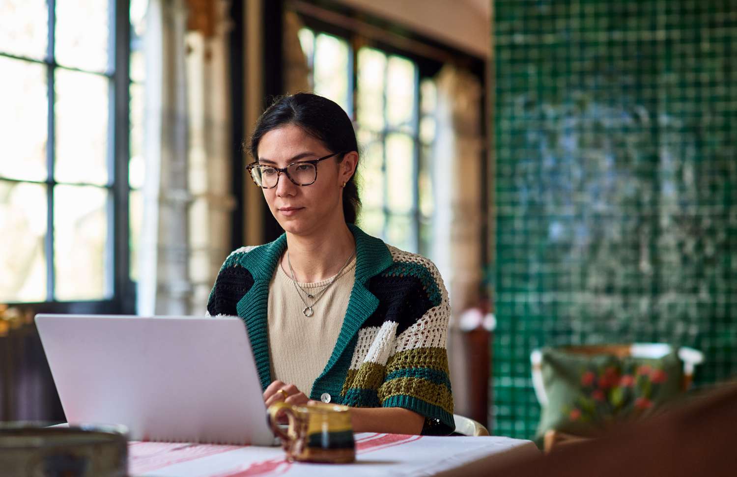 Woman in her home office looking at laptop and working.