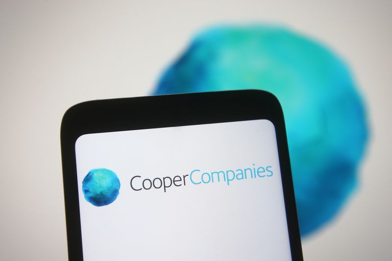 Cooper Companies logo is seen on a smartphone and a PC screen