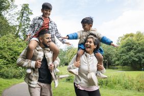 A family outside, with children on shoulders