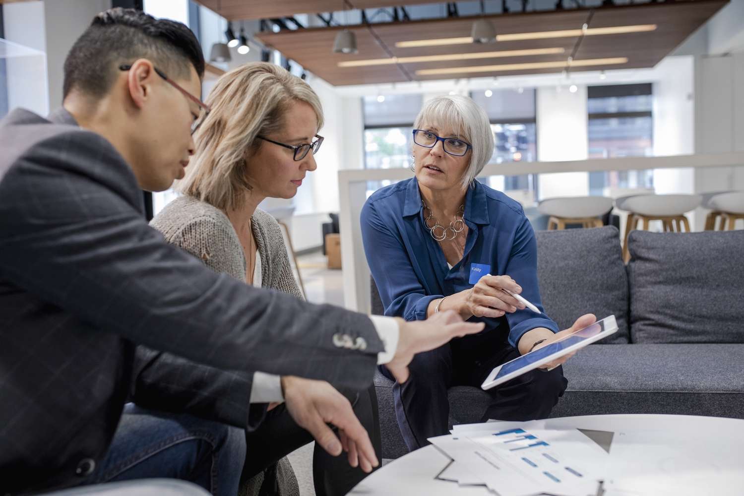 Loan manager with digital tablet meeting with couple in bank