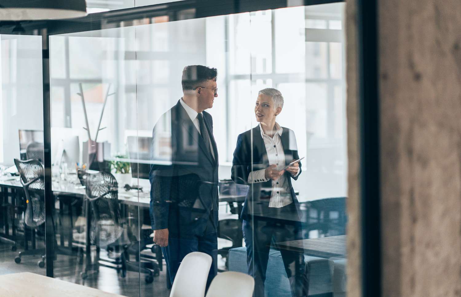 Business people walking and talking discussing ideas in the office.