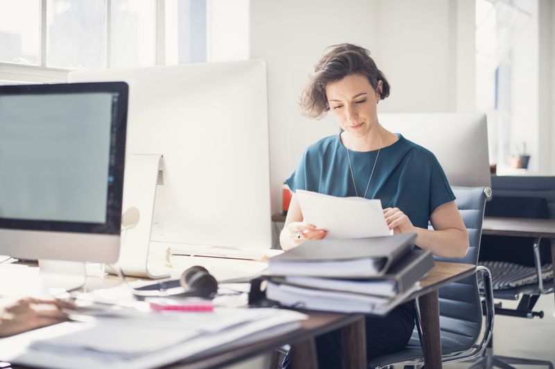 An accountant sits at an office desk reviewing Securities Exchange Commision Form N-2 for the company.