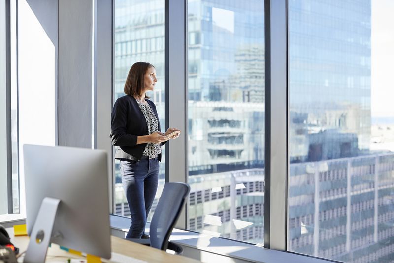Executive looks out of an office window.