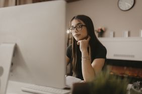 Prospective student reads on her computer about what bank accounts are worth knowing about before she goes to college