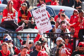 A fan holds a sign "49ers Fans Are at Work Today" during the Kansas City Chiefs' Super Bowl LVIII Victory Parade on Feb 14, 2024