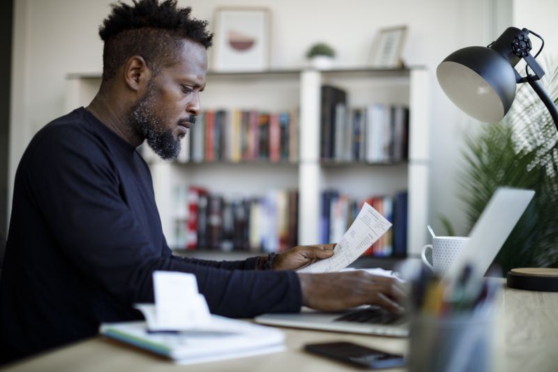Man with papers and a computer at a desk