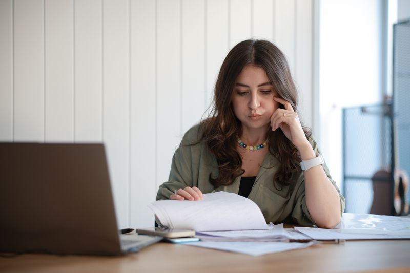 An entrepreneur goes through bills and invoices to find credit card fees that are tax-deductible.
