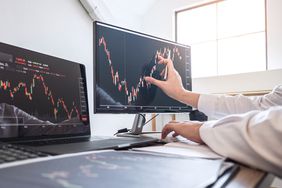 a person touching a computer monitor with a line graph