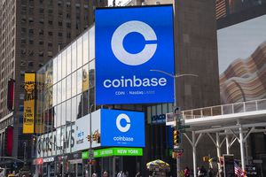Coinbase billboard in an urban area with surrounding buildings and advertisements