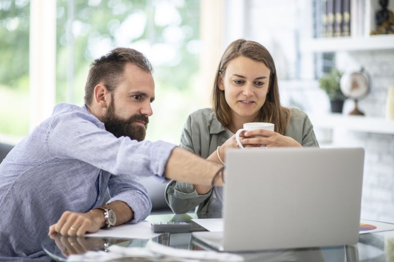Young couple sitting in their kitchen and looking together at online mortgage rates