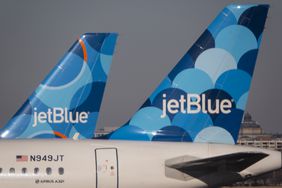 The JetBlue logo is seen on a pair of blue airplane tails.