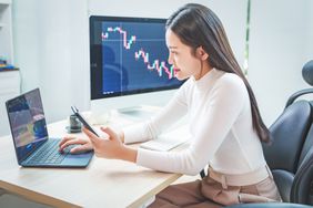 Young trader using smartphone to monitor cryptocurrency prices for Bitcoin IRA investment.