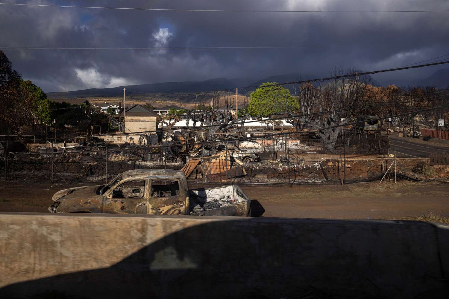 The shadow of a car near homes that burned during the 2023 wildfires in Maui, Hawaii. 